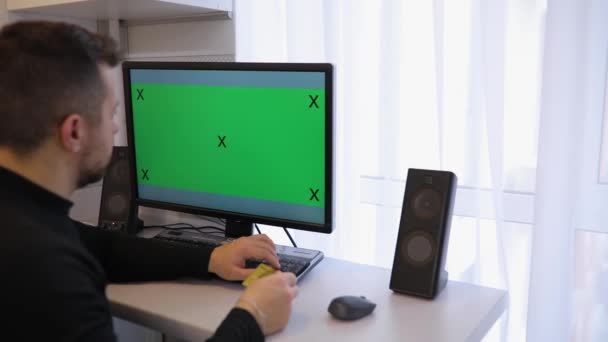 Man Menggunakan Komputer Dengan Layar Hijau Kroma Kunci Rumah Menulis — Stok Video