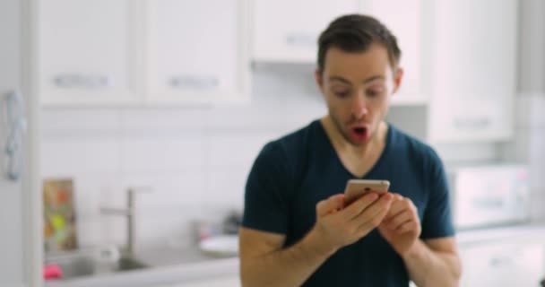 Uomo che mostra lo schermo verde vuoto dello smartphone a casa con sorpresa — Video Stock