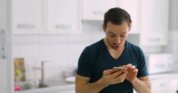 Uomo felice che mostra lo schermo verde vuoto dello smartphone a casa con gioia e fortuna — Video Stock