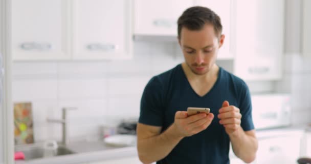 Mann zeigt mit Überraschung leeren grünen Bildschirm seines Smartphones zu Hause — Stockvideo