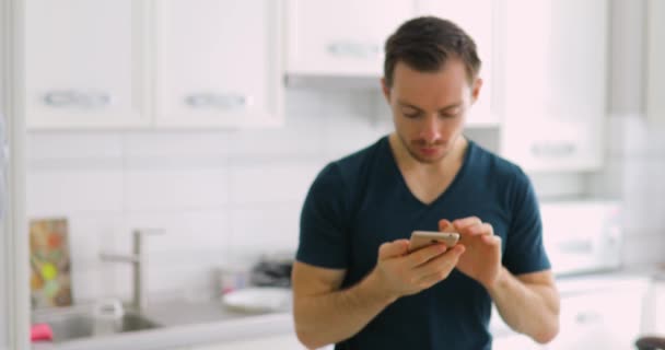 Hombre mostrando la pantalla verde vacía del teléfono inteligente en casa con sorpresa — Vídeos de Stock