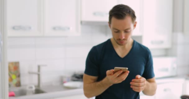 Homem feliz sorte mostrando tela verde vazio de telefone inteligente em casa, ele ganha um jackpot — Vídeo de Stock