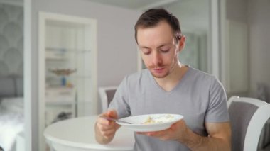 Genç adam bitirmek lezzetli breakfast evde yemek