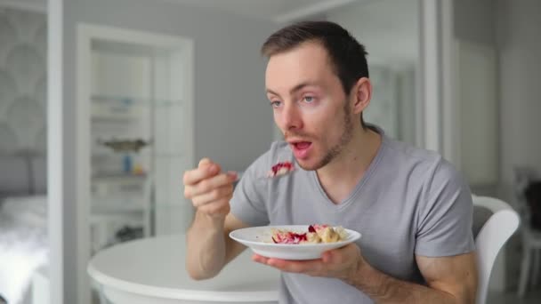 Young man eating healthy breakfast on kitchen