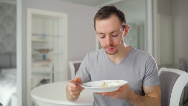 Jovem termina de comer saboroso café da manhã em casa — Vídeo de Stock