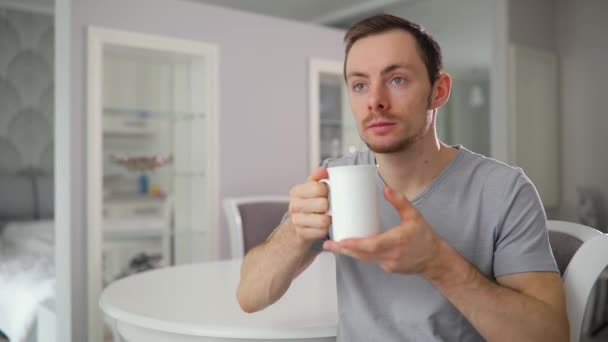 Jovem sozinho bebendo chá em casa cozinha — Vídeo de Stock