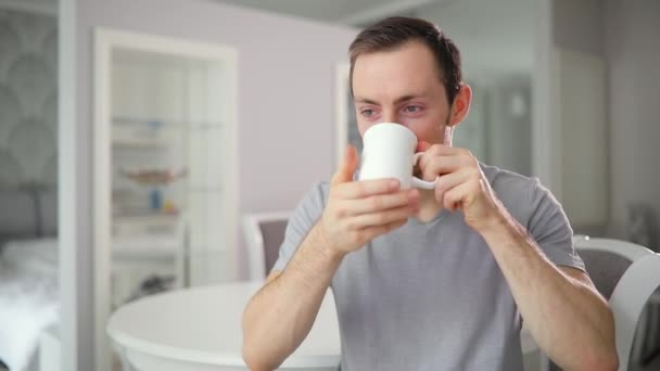 Joven solo bebiendo té en casa cocina con buen humor — Vídeos de Stock