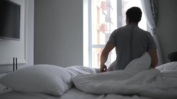 Homem Acorda Manhã Cedo Uma Cama Esticando Braços — Vídeo de Stock