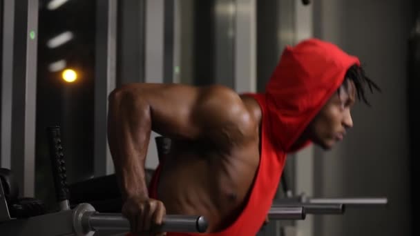 Afro-Américain push ups dans la salle de gym sur les barres parallèles — Video