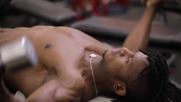 アフリカ系アメリカ人のジムでダンベルで筋肉をポンピング — ストック動画