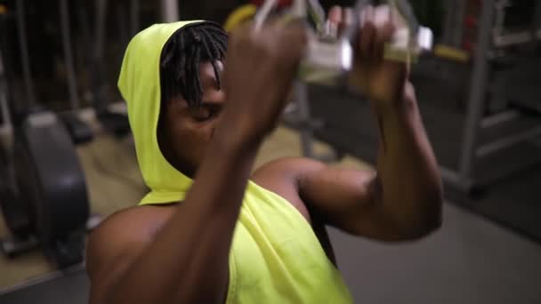 Hombre afroamericano haciendo ejercicio en aparato de entrenamiento en gimnasio — Vídeos de Stock