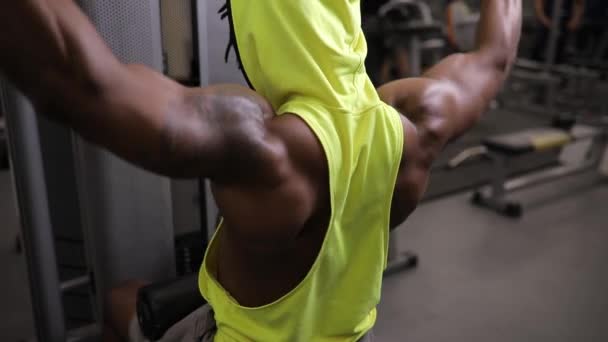 Αφρικανική αμερικανική άνθρωπος κάνοντας άσκηση σε συσκευές κατάρτισης στο γυμναστήριο — Αρχείο Βίντεο