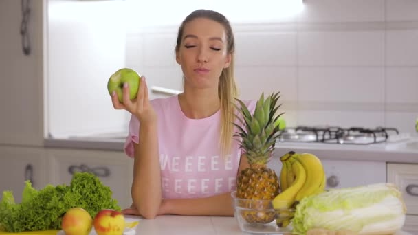 Café da manhã saudável, mulher sorridente feliz comendo maçã fresca verde na cozinha — Vídeo de Stock