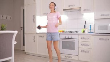 Kaygısız kadın mutfak üzerinde kulaklık müzik sabah dans