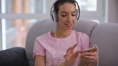 Gülümseyen güzel kadın evde rahat koltukta oturan iyi müzik dinleme