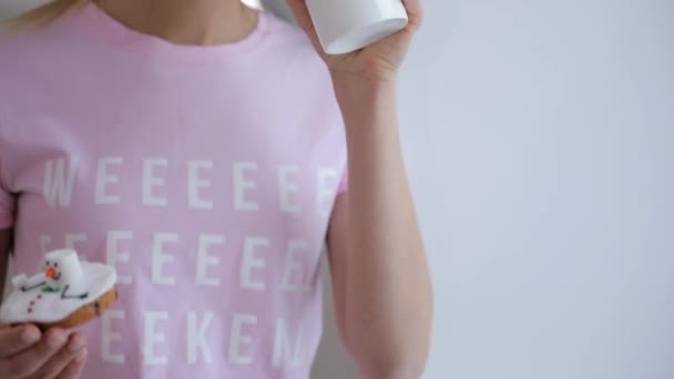 Ung kvinna i rosa t-thirt Njut dricka te med vintern cookie hemma — Stockvideo