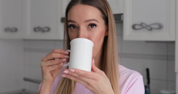 Jovem mulher em rosa t-thirt gosta de beber chá com biscoito de inverno em casa — Vídeo de Stock