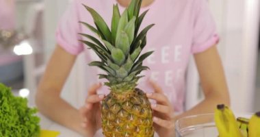 Mutfak üzerinde ananas ile gülümseyen kadın portresi
