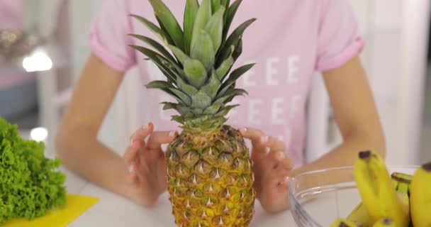 Retrato de mujer sonriente con piña en la cocina — Vídeos de Stock