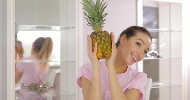 Unga rolig kvinna leker med ananas på kök — Stockvideo