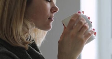 Genç kadın ev pencere çay içme