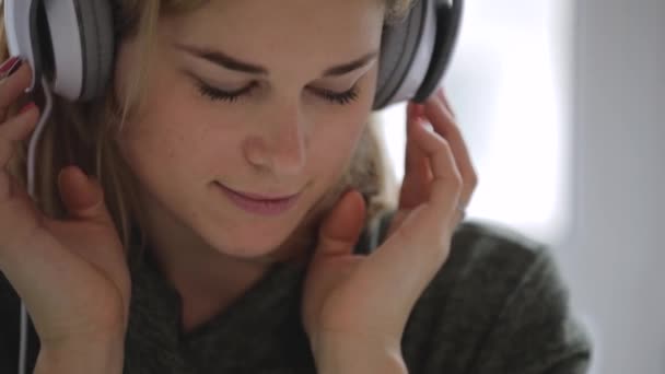 Mujer relajante en casa escuchando buena música en auriculares — Vídeos de Stock