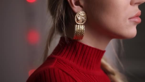 Modelo hermoso de moda en vestido rojo posando pendientes conmovedores, concepto de joyería — Vídeo de stock