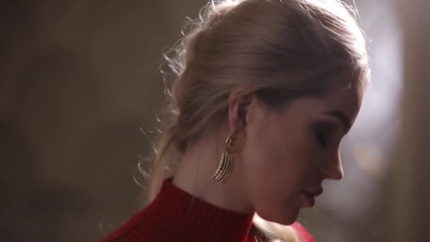 Красивая модель в красном платье позирует с серьгами, привлекательная роскошная девушка — стоковое видео