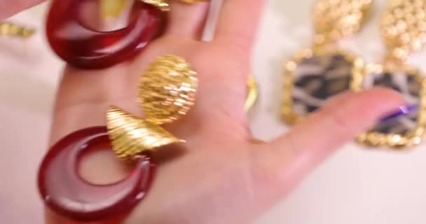 Smycken i en kvinnlig händer, kvinna anläggning örhängen, makro video — Stockvideo