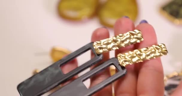 Bijoux dans les mains d'une femme, femme tenant des boucles d'oreilles, macro vidéo 