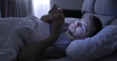 Smartphone vasıl gece önce uyku ile yatakta adam