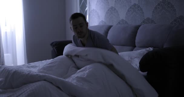 Mal sueño, el hombre se despierta abruptamente en su cama por la noche — Vídeos de Stock