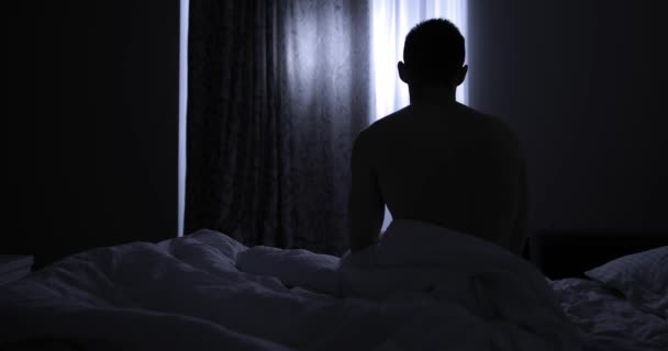 Rear view of man going to bed at night — Stock Video