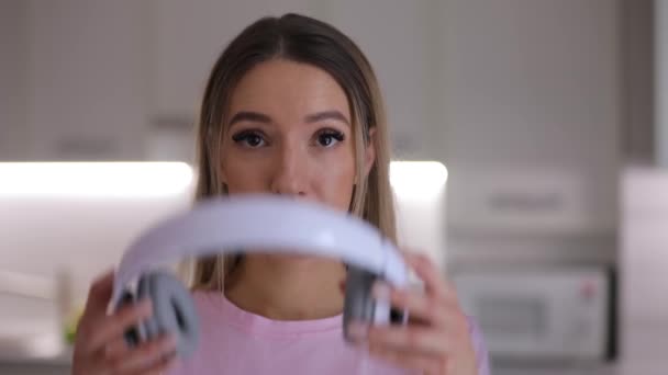 Retrato de mujer feliz se pone los auriculares escuchando música en casa de cerca — Vídeo de stock