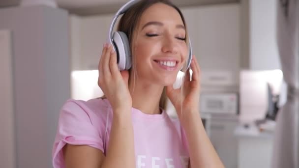 1-st persona vista de feliz mujer pone en auriculares a mí con buena canción en casa — Vídeo de stock