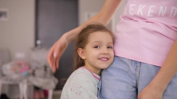 Dochter en haar moeder knuffel thuis in slow motion — Stockvideo