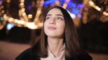 Kadın sarı renk parlaklığı çelenk tarafından dekore edilmiş güzel harika gece sokağa bakıyor
