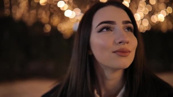 Mujer mirando hermoso callejón nocturno maravilloso decorado con guirnaldas de luminosidad amarilla — Vídeos de Stock