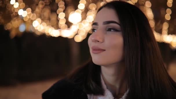 Mujer mirando hermoso callejón nocturno maravilloso decorado con guirnaldas de luminosidad amarilla — Vídeos de Stock