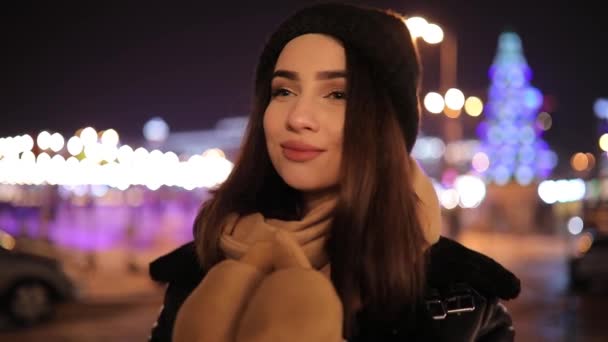Cute woman portrait in night winter city turn face looking at camera — Stock Video