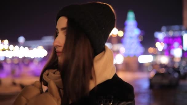 Roztomilá žena portrét v městě Zimní noc proměnit tvář při pohledu na fotoaparát — Stock video