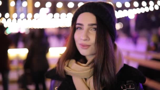 Portrait of woman near ice rink in night winter city turn face — Stock Video