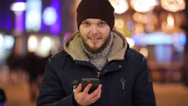 Hombre mostrando una pantalla verde de teléfono inteligente en la ciudad de la noche — Vídeos de Stock