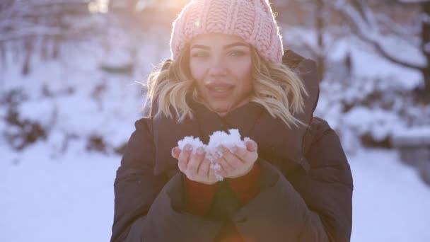 Donna felice soffiando neve dalle mani, rallentamento — Video Stock