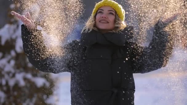 Gelukkige vrouw het gooien van sneeuw op winterdag, slowmotion — Stockvideo