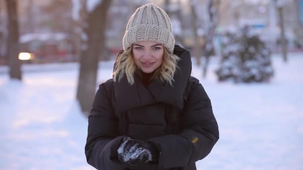 Mooie vrouw gooit sneeuwbal in de winter park, slowmotion — Stockvideo