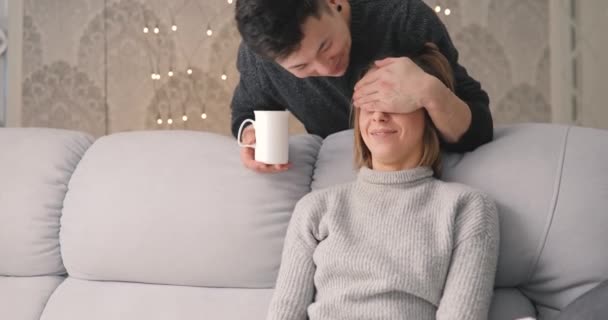 Чоловік доглядає за дівчиною, чоловік дає чашку чаю для своєї люблячої жінки — стокове відео