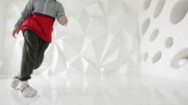 Yerdeki beyaz bir stüdyoda komplike adam serin dans performans taşır