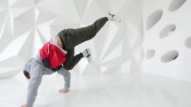 Breakdancer man uitvoeren van coole dans beweegt op de verdieping in een witte studio — Stockvideo