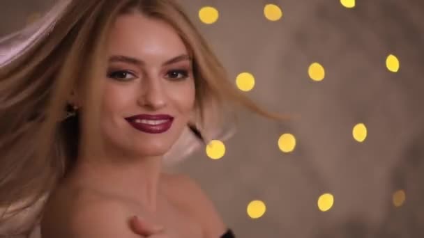 Wunderschöne Mode-Modell mit schönen Haaren posiert, Zeitlupe, gelben Bokeh-Hintergrund — Stockvideo